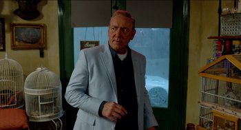 Movie still from “Nine Lives” (2016), directed by Barry Sonnenfeld – A man in a white jacket standing in front of a window; Medium shot, Over the shoulder angle
