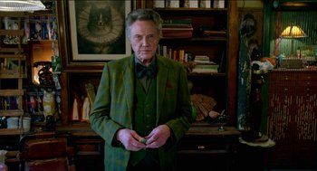 Movie still from “Nine Lives” (2016), directed by Barry Sonnenfeld – An older man wearing a green suit and a bow tie; Medium shot, Low angle
