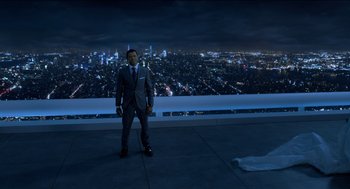 Movie still from “Nine Lives” (2016), directed by Barry Sonnenfeld – A man standing on a balcony overlooking a city; Extreme Wide shot, High angle