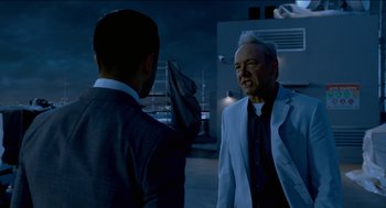 Movie still from “Nine Lives” (2016), directed by Barry Sonnenfeld – A man in a suit talking to another man in a suit; Medium shot, Over the shoulder angle