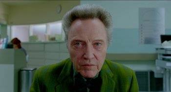 Movie still from “Nine Lives” (2016), directed by Barry Sonnenfeld – An older man with a green jacket and a black bow tie; Close Up shot, Low angle