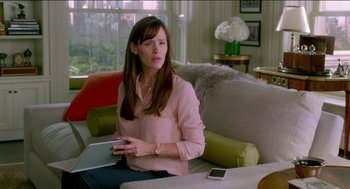 Movie still from “Nine Lives” (2016), directed by Barry Sonnenfeld – A woman sitting on a couch holding a laptop; Medium shot, Over the shoulder angle