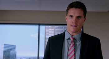 Movie still from “Nine Lives” (2016), directed by Barry Sonnenfeld – A man wearing a suit and tie in a room; Close Up shot, Over the shoulder angle