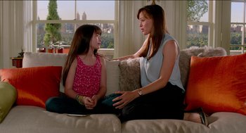 Movie still from “Nine Lives” (2016), directed by Barry Sonnenfeld – A woman sitting on a couch next to a little girl; Medium shot, Over the shoulder angle