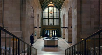 Movie still from “Nine Lives” (2016), directed by Barry Sonnenfeld – A man is walking through an entrance to a building; Extreme Wide shot, High angle