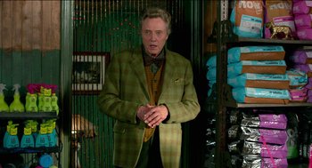 Movie still from “Nine Lives” (2016), directed by Barry Sonnenfeld – An older man in a green suit standing in a room; Medium shot, Over the shoulder angle