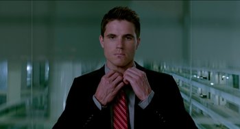 Movie still from “Nine Lives” (2016), directed by Barry Sonnenfeld – A man in a black suit and a red striped tie; Close Up shot, Low angle