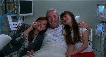 Movie still from “Nine Lives” (2016), directed by Barry Sonnenfeld – A man and two young girls in a hospital bed; Medium shot, High angle