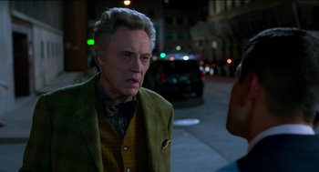 Movie still from “Nine Lives” (2016), directed by Barry Sonnenfeld – An older man wearing a green jacket on the sidewalk; Close Up shot, Over the shoulder angle