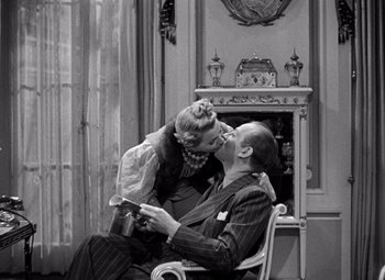 Movie still from “Ninotchka” (1939), directed by Ernst Lubitsch – An old photo of a man and a young girl kissing; Medium shot, High angle