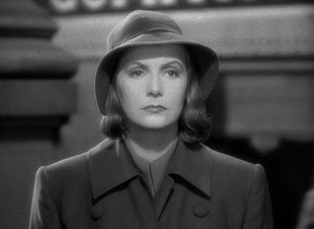 Movie still from “Ninotchka” (1939), directed by Ernst Lubitsch – A woman wearing a hat and a coat; Close Up shot, Over the shoulder angle