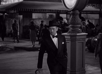 Movie still from “Ninotchka” (1939), directed by Ernst Lubitsch – A black and white photo of a man walking down the street; Medium shot, High angle