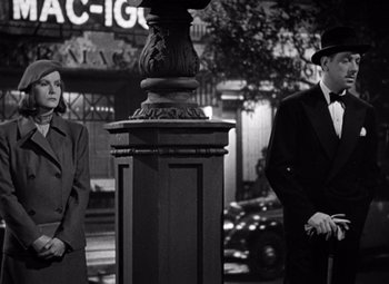 Movie still from “Ninotchka” (1939), directed by Ernst Lubitsch – A man and a woman standing next to each other on the street; Medium shot, Low angle