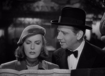 Movie still from “Ninotchka” (1939), directed by Ernst Lubitsch – A man and a woman wearing hats looking at each other; Close Up shot, Low angle