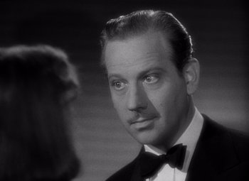 Movie still from “Ninotchka” (1939), directed by Ernst Lubitsch – A man wearing a suit and bow tie; Close Up shot, Over the shoulder angle