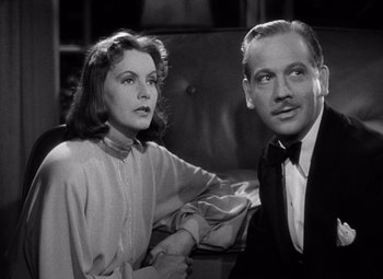 Movie still from “Ninotchka” (1939), directed by Ernst Lubitsch – An old photo of a man and a woman sitting next to each other; Close Up shot, Low angle