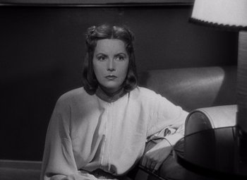 Movie still from “Ninotchka” (1939), directed by Ernst Lubitsch – A black and white photo of a woman sitting on a couch; Close Up shot, Low angle