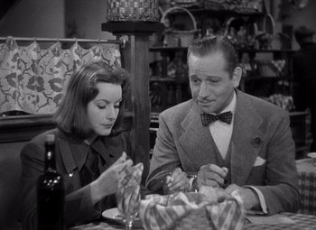 Movie still from “Ninotchka” (1939), directed by Ernst Lubitsch – A man and a woman sitting at a dinner table; Medium shot, High angle