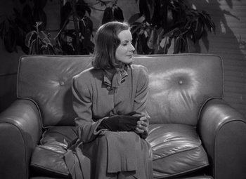 Movie still from “Ninotchka” (1939), directed by Ernst Lubitsch – A woman sitting on top of a leather couch; Medium shot, High angle