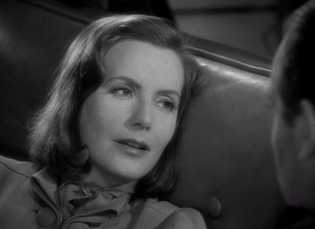 Movie still from “Ninotchka” (1939), directed by Ernst Lubitsch – An old photo of a woman sitting in a chair; Close Up shot, Over the shoulder angle