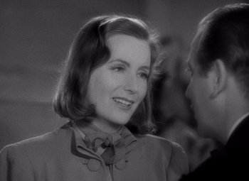 Movie still from “Ninotchka” (1939), directed by Ernst Lubitsch – An old photo of a woman smiling at the camera; Close Up shot, Over the shoulder angle