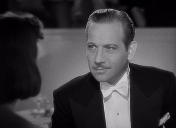 Movie still from “Ninotchka” (1939), directed by Ernst Lubitsch – A man in a tuxedo sitting in front of a woman; Close Up shot, Over the shoulder angle