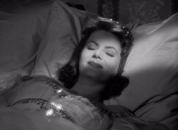 Movie still from “Ninotchka” (1939), directed by Ernst Lubitsch – A black and white photo of a woman laying in a bed; Close Up shot, High angle