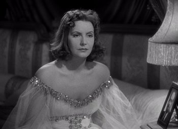 Movie still from “Ninotchka” (1939), directed by Ernst Lubitsch – A black and white photo of a woman in a dress; Close Up shot, Over the shoulder angle