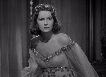 Movie still from “Ninotchka” (1939), directed by Ernst Lubitsch – A black and white photo of a woman in a dress; Close Up shot, Over the shoulder angle