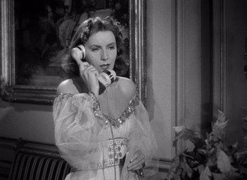Movie still from “Ninotchka” (1939), directed by Ernst Lubitsch – A woman in a white dress talking on a phone; Medium shot, High angle