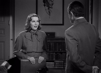 Movie still from “Ninotchka” (1939), directed by Ernst Lubitsch – A woman sitting in front of a man in a suit; Medium shot, Over the shoulder angle