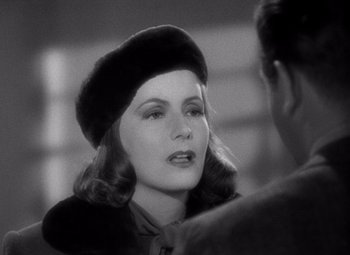 Movie still from “Ninotchka” (1939), directed by Ernst Lubitsch – A woman wearing a fur hat talking to a man; Close Up shot, Over the shoulder angle
