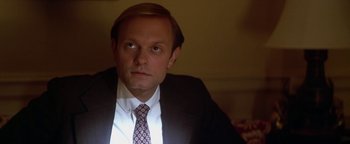 Movie still from “Nixon” (1995), directed by Oliver Stone – A person wearing a suit and tie; Close Up shot, High angle