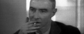 Movie still from “Nixon” (1995), directed by Oliver Stone – A black and white photo of a man smoking a cigarette; Extreme Close Up shot, Over the shoulder angle