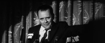 Movie still from “Nixon” (1995), directed by Oliver Stone – A black and white photo of a man in a suit and tie; Close Up shot, Low angle