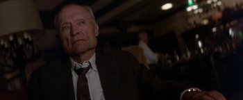 Movie still from “Nixon” (1995), directed by Oliver Stone – An older man wearing a suit and tie; Close Up shot, Low angle