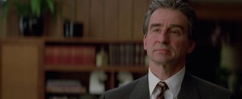 Movie still from “Nixon” (1995), directed by Oliver Stone – A person wearing a suit and tie; Close Up shot, Over the shoulder angle