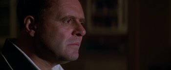 Movie still from “Nixon” (1995), directed by Oliver Stone – A man's face in a dark room; Close Up shot, Low angle