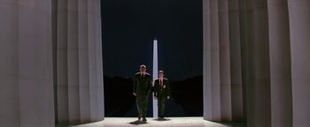 Movie still from “Nixon” (1995), directed by Oliver Stone – Two men standing in front of the washington monument at night; Wide shot, Low angle