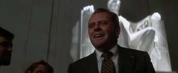 Movie still from “Nixon” (1995), directed by Oliver Stone – A person wearing a suit and tie; Close Up shot, Low angle