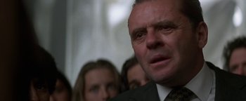 Movie still from “Nixon” (1995), directed by Oliver Stone – A person wearing a suit and tie; Close Up shot, Low angle