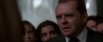 Movie still from “Nixon” (1995), directed by Oliver Stone – A person wearing a suit and a tie; Close Up shot, Low angle