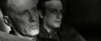 Movie still from “Nixon” (1995), directed by Oliver Stone – A black - and - white photo of a man and a woman's face; Close Up shot, Over the shoulder angle