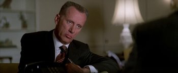 Movie still from “Nixon” (1995), directed by Oliver Stone – A man in a suit and tie; Close Up shot, Low angle