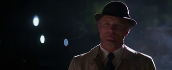 Movie still from “Nixon” (1995), directed by Oliver Stone – A man wearing a suit and a bowler hat; Close Up shot, Low angle