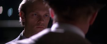 Movie still from “Nixon” (1995), directed by Oliver Stone – A person looking at a mirror; Close Up shot, Over the shoulder angle