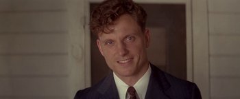 Movie still from “Nixon” (1995), directed by Oliver Stone – A person wearing a suit and tie; Close Up shot, Over the shoulder angle