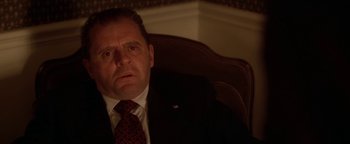 Movie still from “Nixon” (1995), directed by Oliver Stone – A person wearing a suit and tie; Close Up shot, Low angle