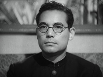 Movie still from “No Regrets for Our Youth” (1946), directed by Akira Kurosawa – A man wearing glasses and a black shirt; Close Up shot, Low angle