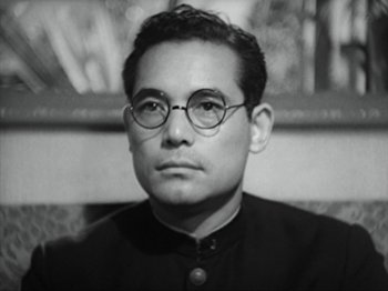 Movie still from “No Regrets for Our Youth” (1946), directed by Akira Kurosawa – A man wearing glasses and a priest's outfit; Close Up shot, Low angle